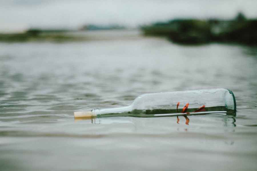 selective focus photo of bottle floating on body of water