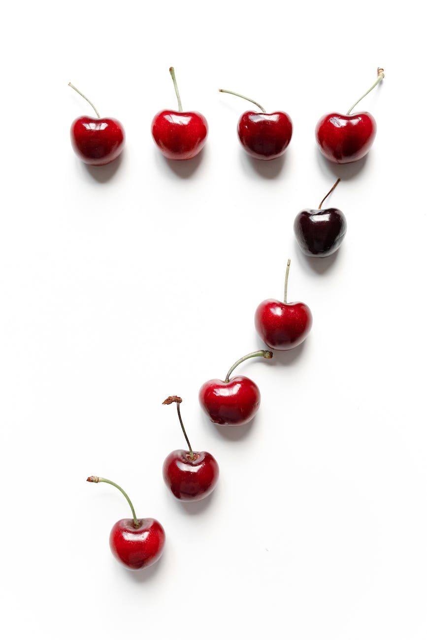 photo of ripe cherries on white surface