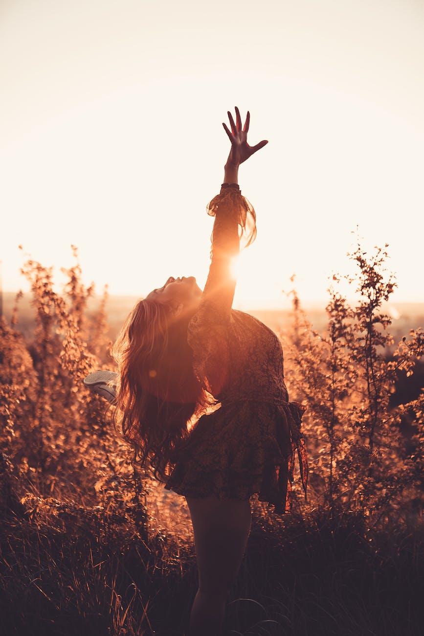 graceful woman with raised arm in long grass